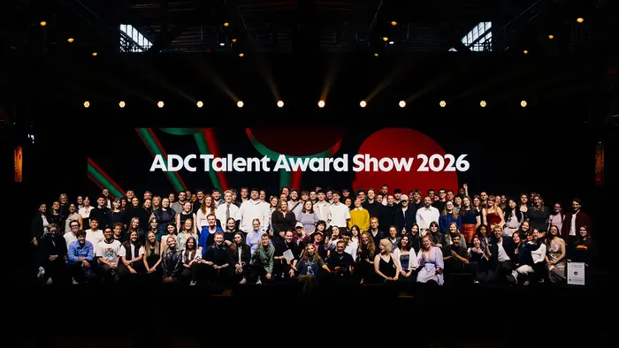 Eine große Gruppe von Menschen posiert gemeinsam auf einer Bühne vor einem Hintergrund mit der Aufschrift „ADC Talent Award Show 2026“. 
