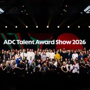 Eine große Gruppe von Menschen posiert gemeinsam auf einer Bühne vor einem Hintergrund mit der Aufschrift „ADC Talent Award Show 2026“. 