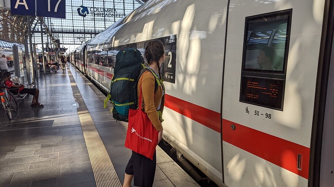 Reise Eine Frau mit einen großen Rucksack auf Ihren Schultern, steigt an einem Hauptbahnhof in einen Zug ein