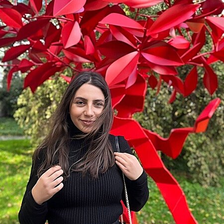 Filiz Ceyhan Frau vor roten Blumen
