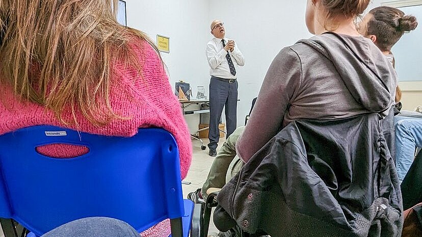 zwei Frauen sitzen auf Stühlen und werden von hinten fotografiert