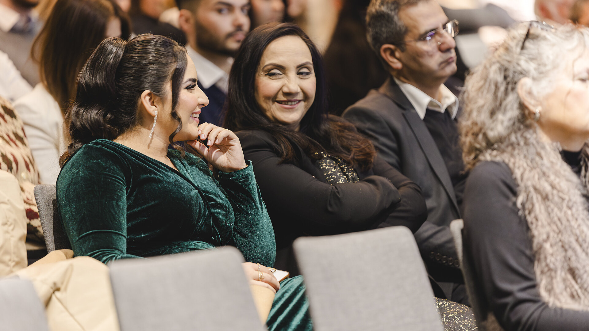 Menschen sitzen nebeneinander und lachen 