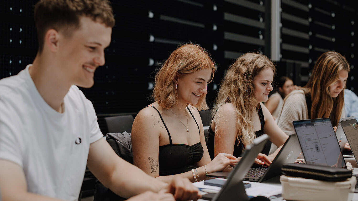 Studierende des Studiengangs Media Mangament Ein Student und mehrere Studentinnen sitzen vor ihren Laptops