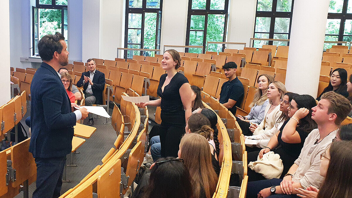 Prof. Dr. Heiko Schön und die Student:innen sitzen in einem Vorlesungssaal
