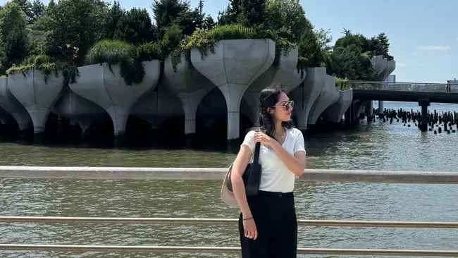 Sobia Khan steht vor einem Metallgeländer. Hinter ihr befindet sich ein Gewässer