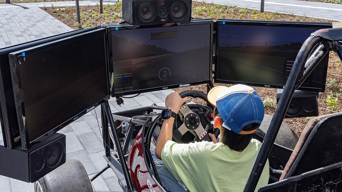 Ein Kind sitzt in einem Rennwagen-Simulator