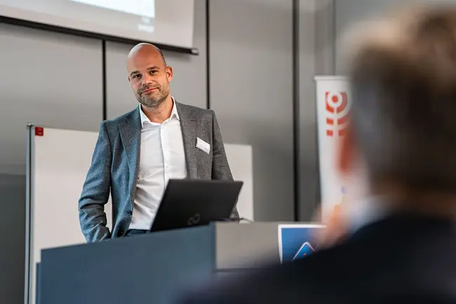 Tobias Steenweg von UniNow blickt während seines Vortrags ins Publikum.