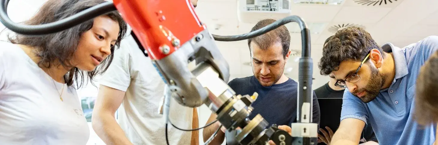 Studierende arbeiten mit einem Roboter