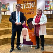 Der hessische Justizminister Christian Heinz steht gemeinsam mit Hochschulpräsidentin Prof. Dr. Eva Waller vor einem Roll-up des Frauen- und Gleichstellungsbüros der Hochschule RheinMain.