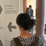 Eine Besucherin der Ausstellung steht vor einer Wand auf der die Namen "Horst Steckem" und " Regina Harasta" zu lesen sind