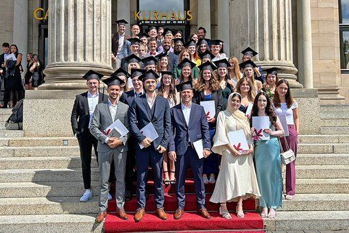 Gruppenfoto der Absolvent:innen des Studiengangs International Management (B. A.) vor dem Kurhaus Wiesbaden