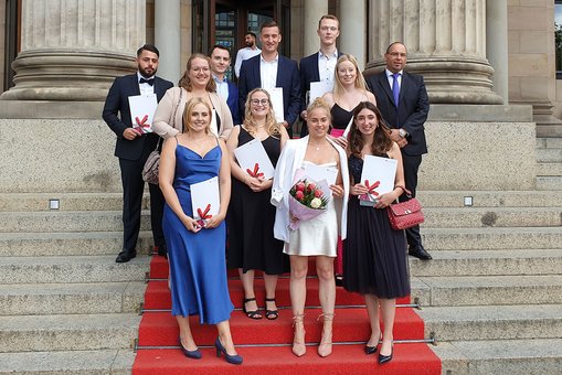 Gruppenfoto mit Absolvent:innen des Fachbereichs Wiesbaden Business School vor dem Kurhaus Wiesbaden