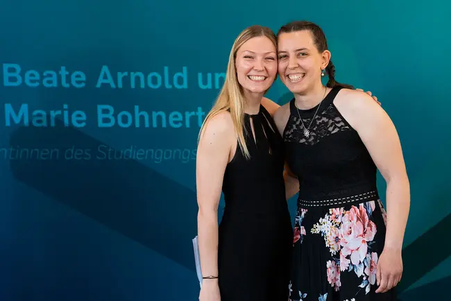 Die Absolventinnen Marie Bohnert und Beate Arndold lächeln in die Kamera.