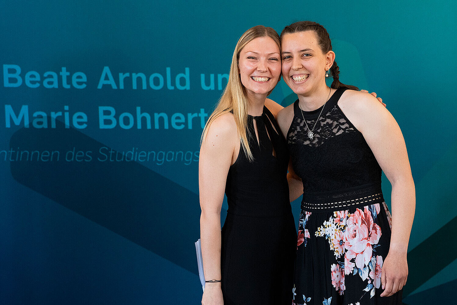 Die Absolventinnen Marie Bohnert und Beate Arndold lächeln in die Kamera.