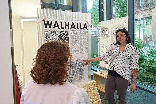 Die Architekturstudentin Vanessa Klassen erläutert einer Besucherin der Ausstellungseröffung in den Räumlichkeiten der IHK Wiesbaden ihren Entwurf