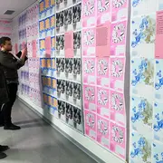 Zwei Personen sehen sich die Motive des Hochschulkalenders 2026 an.