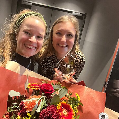 Studentinnen mit Blumenstrauß