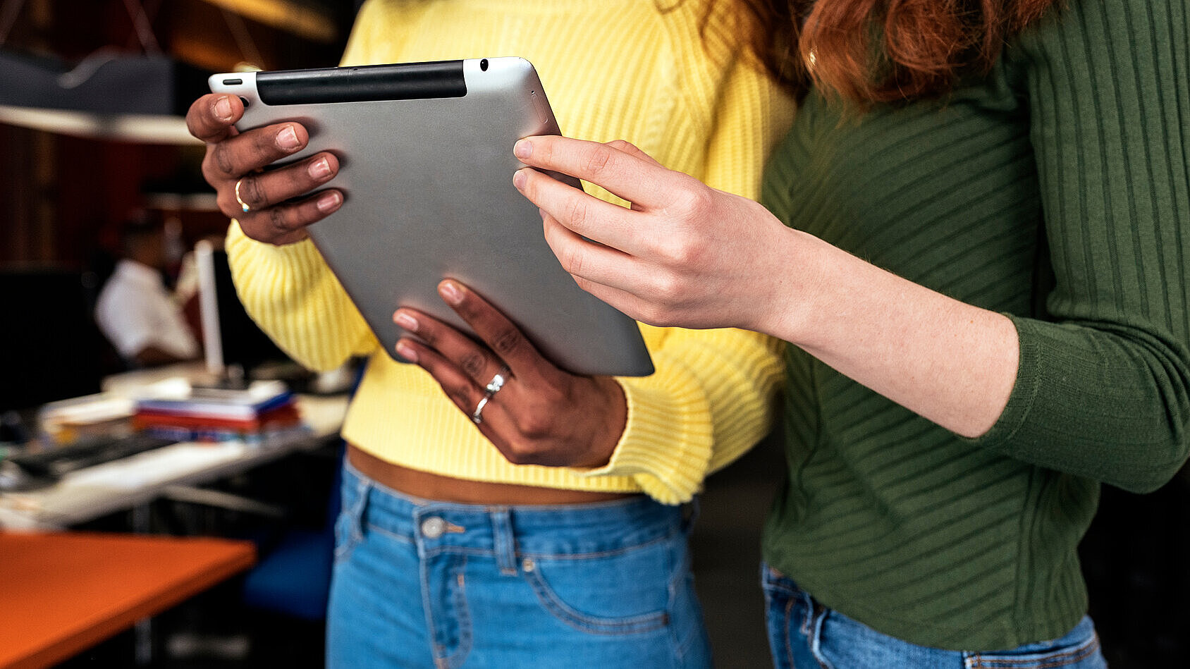 Zwei Frauen halten Tablet Zwei Frauen halten Tablet gemeinsam in der Hand