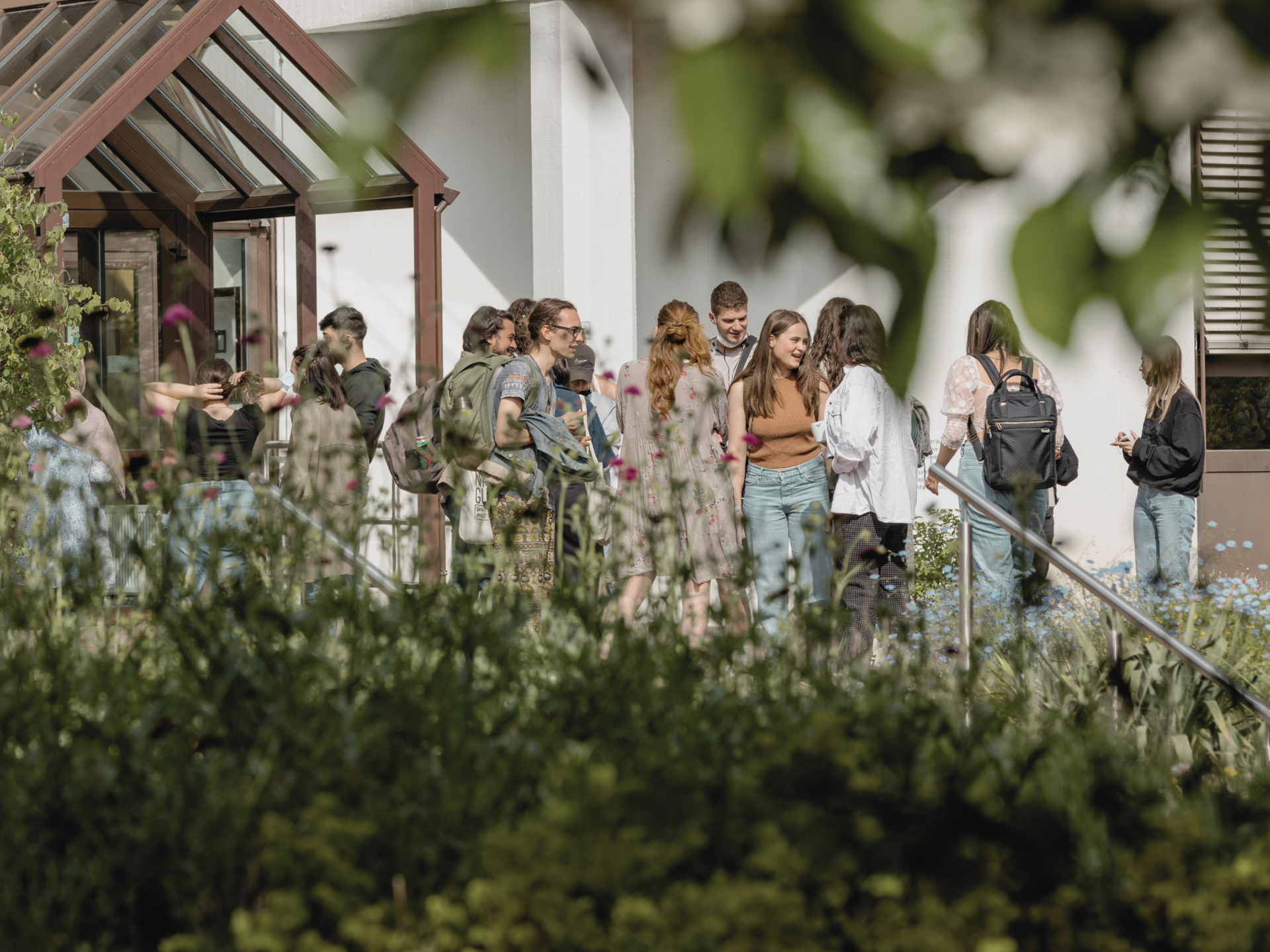 Studierende stehen in einer Gruppe vor dem E-Gebäude des Campus
