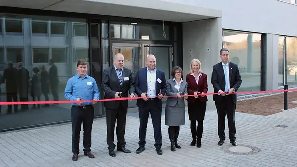 Offizielle Vertreter:innen der Hochschule, der Stadt Rüsselsheim und des Landes Hessen durchtrennen ein rotes Band vor dem neuen Gebäude G