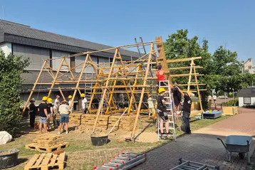 Students working on the scaffolding of a pavilion