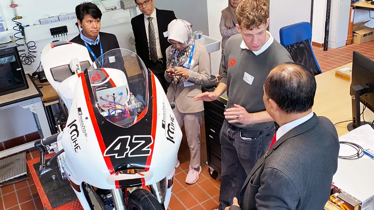 Die Delegation betrachtet das Rennmotorrad von RheinVolt Motorsport