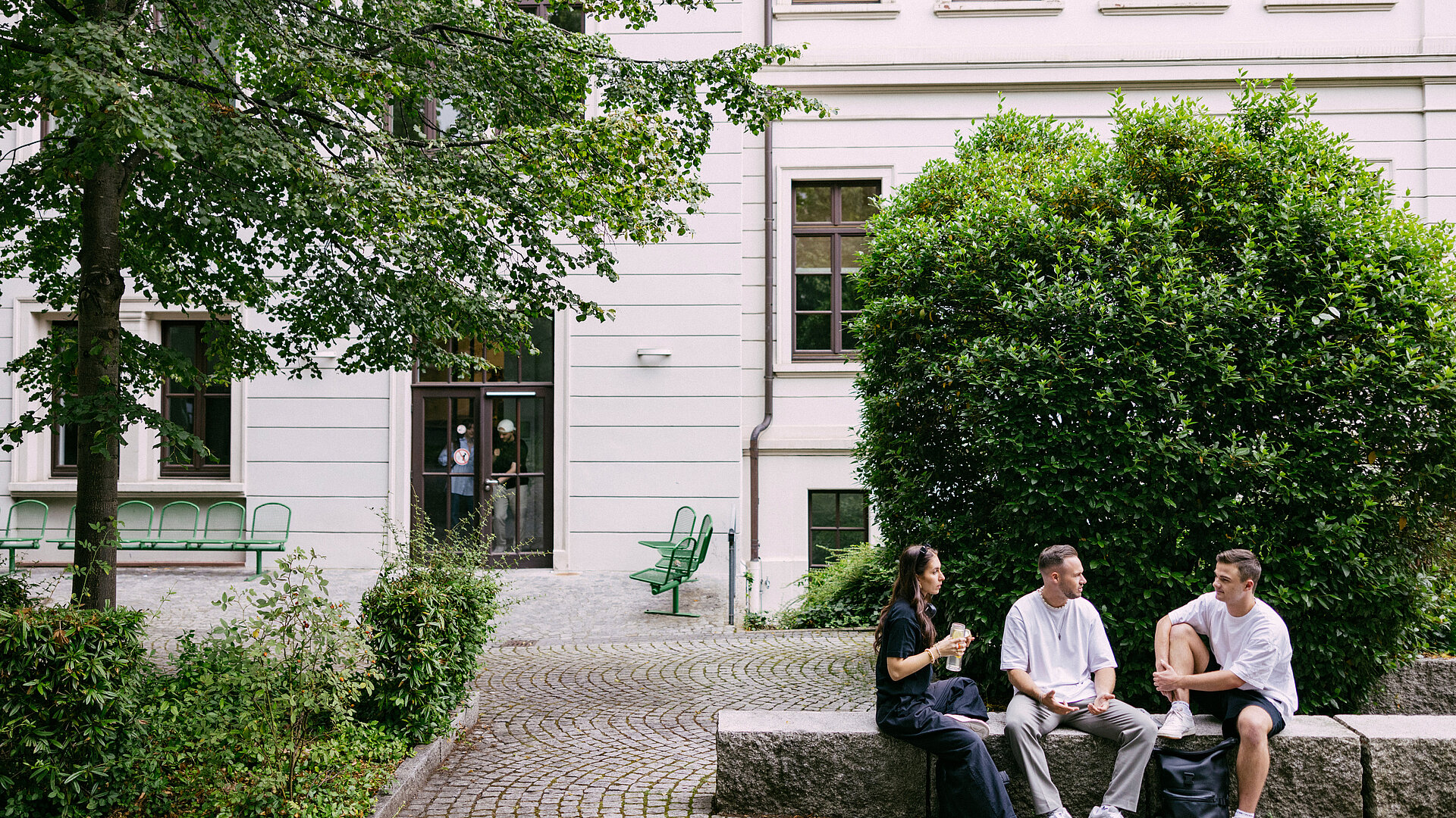 Studierende sitzen im Hof der Wiesbaden Business School