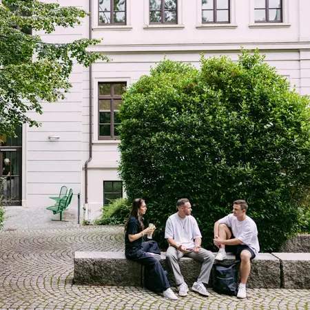 Studierende sitzen im Hof der Wiesbaden Business School