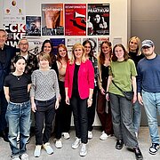 Gruppenfoto des Studierendenteams vor den Plakatentwürfen. 