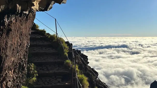 Auslandssemester Eric Bingenheimer Eine Steintreppe auf einem Wanderweg. Von ihr aus schaut man von oben auf die Wolkendecke