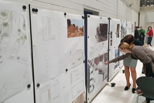 Zwei Besucherinnen der Finissage des Studiengangs Architektur betrachten die ausgestellten Entwürfe