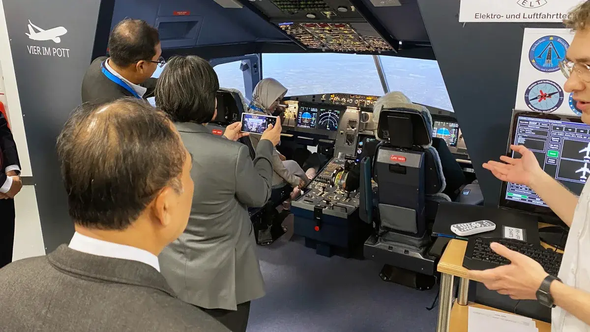 Die Delegation betrachtet den Flugsimulator