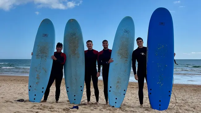 Auslandssemester Eric Bingenheimer Vier Männer stehen am Strand und halten Surfbretter in den Händen