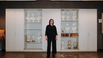 Studierende steht im Zeichensaal - im Hintergrund die Büstensammlung