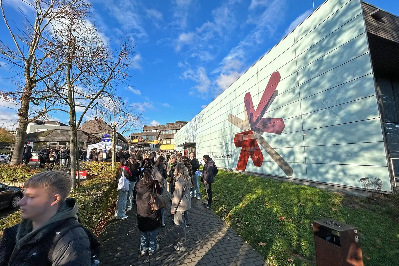 Schüler:innen warten auf dem Campus Kurt-Schumacher-Ring der Hochschule RheinMain auf den Beginn des Hochschulinformationstags 2025.
