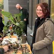 Zwei Personen stehen an einem Tisch mit Pflanzen