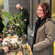 Zwei Personen stehen an einem Tisch mit Pflanzen