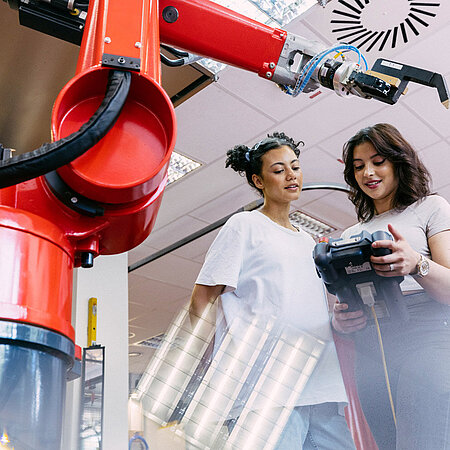 Studentinnen arbeiten mit einem Laseraufbau am Campus in Rüsselsheim
