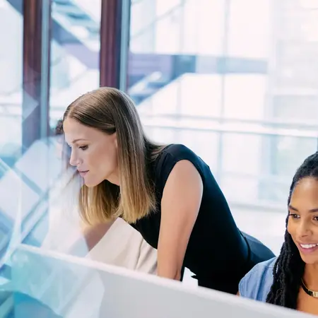 Studierende und Dozentin arbeiten an PCs