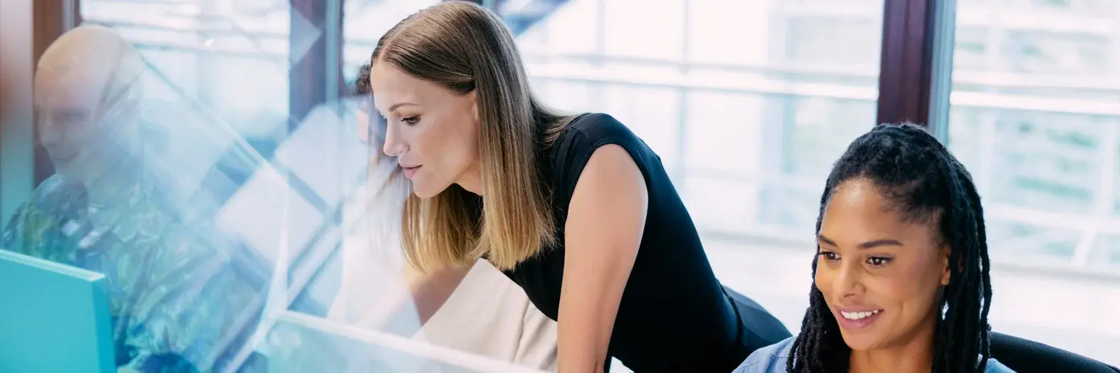 Studierende und Dozentin arbeiten an PCs