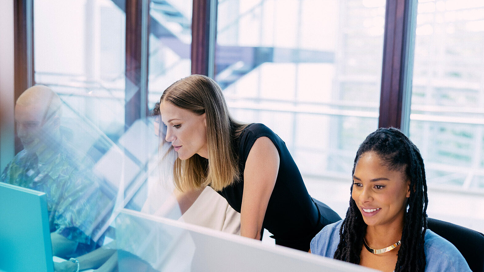 Studierende und Dozentin arbeiten an PCs