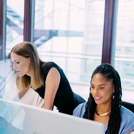 Studierende und Dozentin arbeiten an PCs