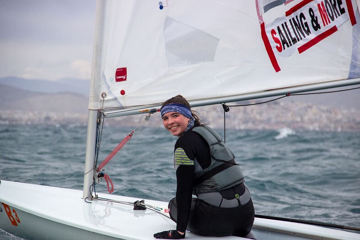 Jennifer Weißenberger sitzt auf einem Segelboot und lächelt in die Kamera