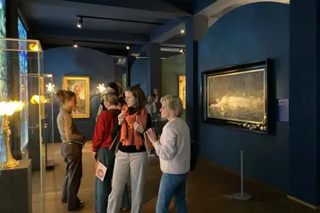 Mitarbeiterinnen und Studentinnen des Fachbereichs Architektur und Bauingenieurwesen stehen im Museum Wiesbaden vor Skulpturen und Gemälden.