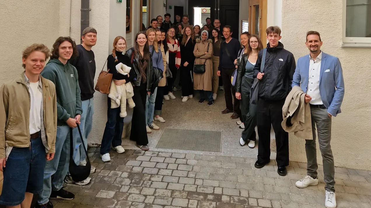 Eine Gruppe von etwa 30 Baukulturerbe-Studierenden steht in einem Durchgang. Sie lächeln freundlich in die Kamera. Die Studierenden befinden sich auf einer Exkursion in Wien.