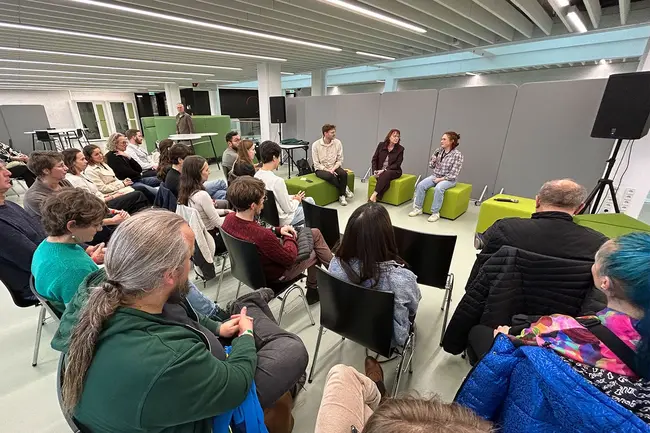 Sustainable Future Days Bescher:innen der Veranstaltung verfolgen eine Podiumsdiskussion.