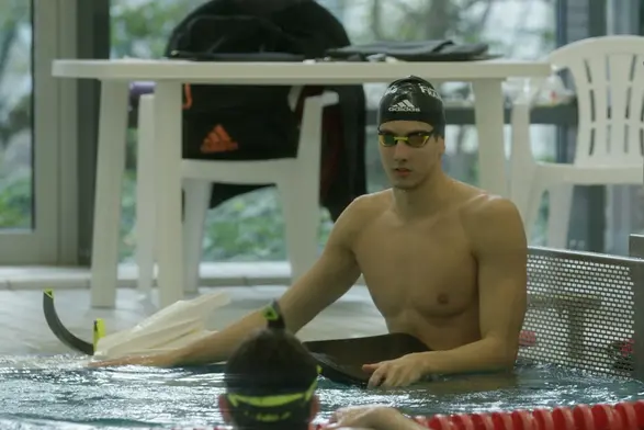 Lucas Matzerath sitzt am Beckenrand  eines Schwimmbeckens