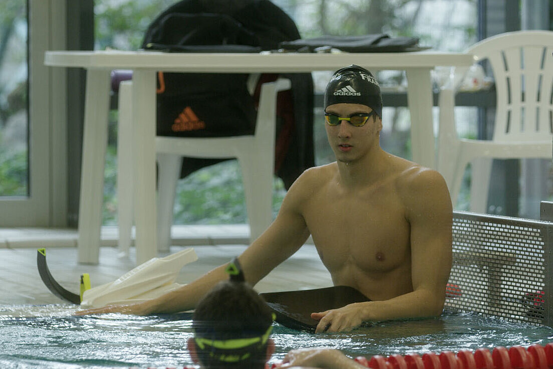 Porträt von Lucas Matzerath, Schwimmen Lucas Matzerath sitzt am Beckenrand eines Schwimmbeckens