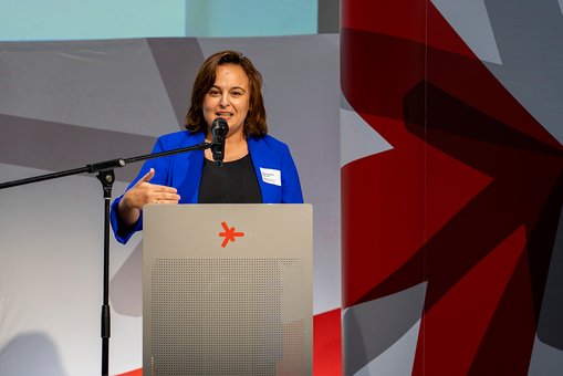 Ayse Asar, Staatssekretärin im Hessischen Ministerium für Wissenschaft und Kunst, steht während ihres Grußworts am Rednerpult und spricht in ein Mikrofon