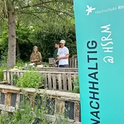 Mitarbeiter des Nachhaltigkeitsbrüs der Hochschule RheinMain stehen gemeinsam mit der Referentin Sybille Fuchs in Kurts Garten auf dem Campus Kurt-Schumacher-Ring der Hochschule RheinMain